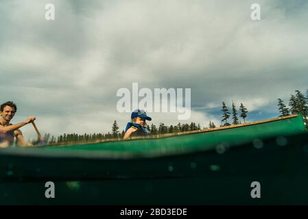 A young girl rides in a canoe with her dad on Lost Lake in Oregon. Stock Photo