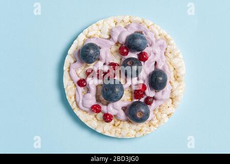 healthy food rice cake sandwich isolated on light blue background. Sweet Rice cakes with yogurt, and blueberry. Stock Photo