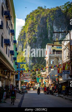 A street looking at dramatic cliffs in downtown El Nido, Philippines on a sunny day Stock Photo