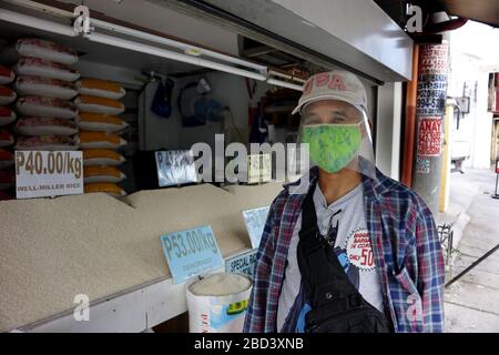 Antipolo City, Philippines - April 4, 2020: Man with improvised personal protective equipment and face mask buy rice from a store during the lockdown Stock Photo