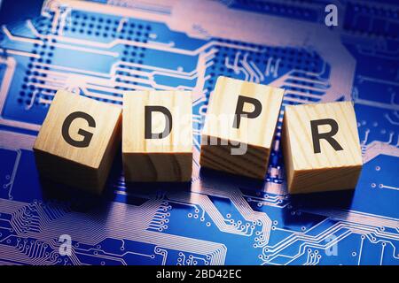 Wooden cubes with text on microcircuit background, symbolizing the EU General Data Protection Regulation or GDPR Stock Photo