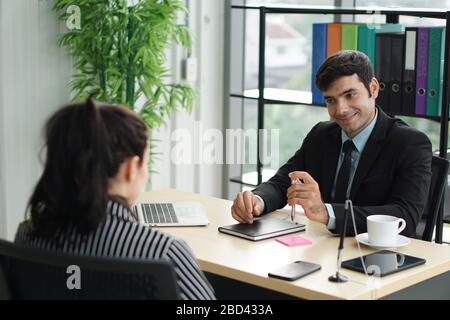 Young employers in black suits are evaluating job applicants by asking marketing strategy questions. Candidate didn't understand what the employer was Stock Photo