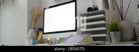 Cropped shot of office desk with blank screen computer, tablet, office supplies and decorations in minimal office room Stock Photo