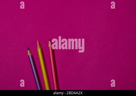 Multi colored crayons at magenta background with copy space. Stock Photo