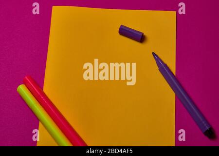 Multi colored felt tip pens at yellow and magenta background with copy space. Stock Photo