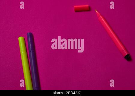 Multi colored felt tip pens at magenta background with copy space. Stock Photo