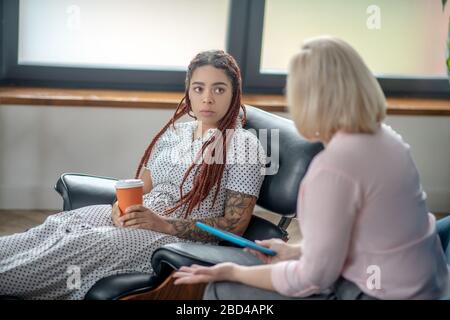 Young woman with dreads talking to the psychologist Stock Photo