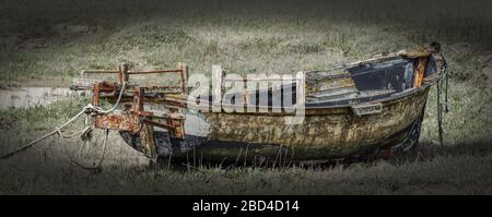 wrecked boat sitting on tired up river bed Stock Photo