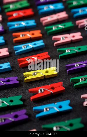 Small clothespins on a black table. Stock Photo