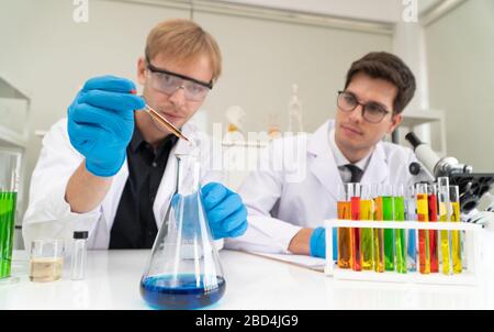 Scientists or doctors are researching to find new Medicine and prevent, destroy new strains of the virus (Coronavirus) through tube and beaker in a ch Stock Photo
