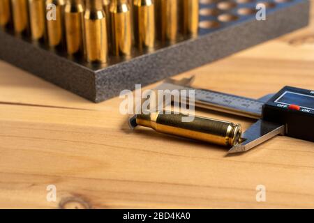 Production of cartridges for a rifle, reload. Measurement of the empty cartridges with a caliper Stock Photo