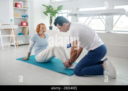 Nice active woman having her feet held Stock Photo