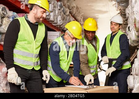 Pickers and warehouse workers in the warehouse with package and checklist on clipboard Stock Photo