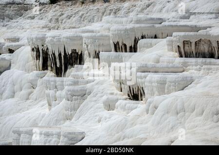 Travertine terrace formations at Pamukkale, Turkey. Travertine -  a sedimentary rock deposited by water from the hot springs. Stock Photo