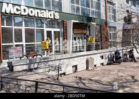 Kiev, Ukraine -April 06, 2020: Couriers and delivery services Glovo in the queue near the McDonald's. Ukraine stops bars, restaurants and shopping cen Stock Photo