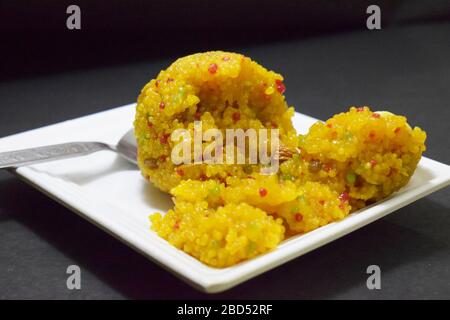 Indian Sweet Moti Choor Laddu in White Plate Top View on Black Background Close-Up Stock Photograph Image Stock Photo