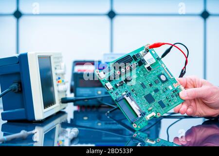 Debugging electronics device. PCB witch microcontroller in electronics laboratory Stock Photo