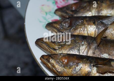 Smoked fresh fish mackerel lies hot on a ceramic plate Stock Photo