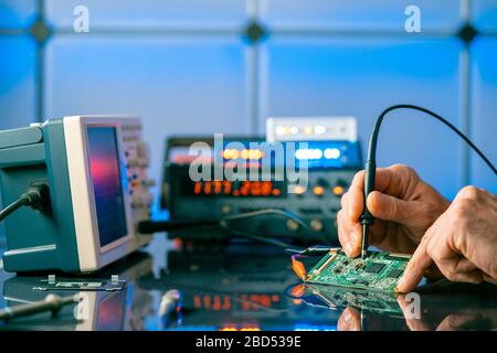 Debugging electronics device. PCB witch microcontroller in electronics laboratory Stock Photo