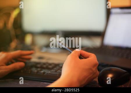 pointing laptop monitor with digital pen. working seriously with concentration. hand typing on keyboard number pad while letting mouse rest on the tab Stock Photo