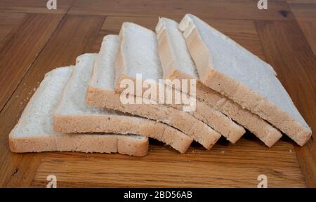 Half a dozen slices of white bread photographed in a kitchen setting Stock Photo
