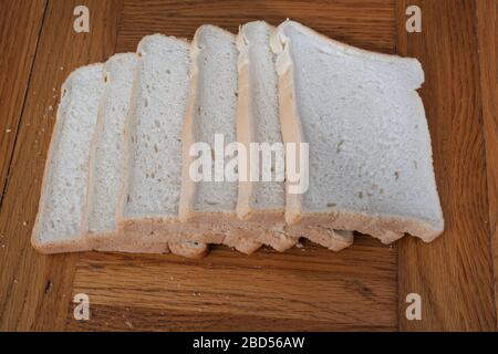 Six slices of plain white bread photographed in a kitchen setting Stock Photo
