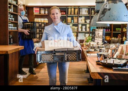 Hamburg, Germany. 07th Apr, 2020. Cornelia Poletto, TV cook, carries several packaged food portions from her restaurant. Poletto regularly cooks food for needy senior citizens and delivers it himself. Credit: Axel Heimken/dpa/Alamy Live News Stock Photo