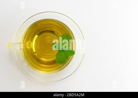 Mint tea in a transparent cup is isolated on a white background. Flat lay. Copy space. Stock Photo