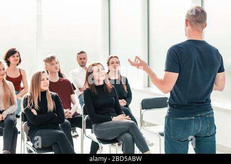 speaker makes a report for a group of diverse young people. Stock Photo