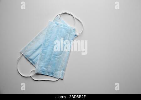 Face masks reduce the chance of spreading airborne diseases. Blue disposable medical sanitary surgical masks on white table, top view. Shortage of sur Stock Photo