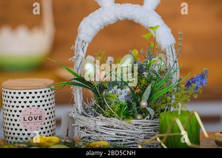 Festive Easter basket with flowers on the table Stock Photo