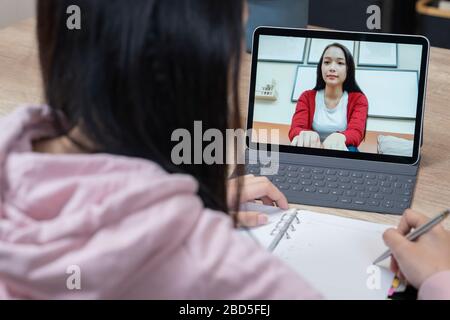 An asian women talking while video chatting with colleague. Stock Photo