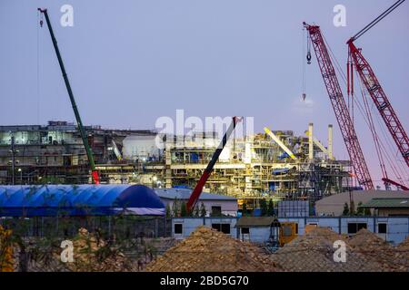 Buildings and cranes under evening construction Stock Photo