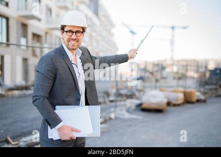 Young and attractive architect / civil engineer at work on a construction site Stock Photo