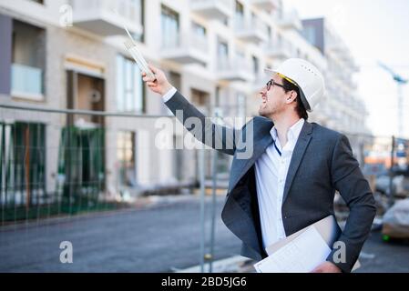 Young and attractive architect / civil engineer at work on a construction site Stock Photo