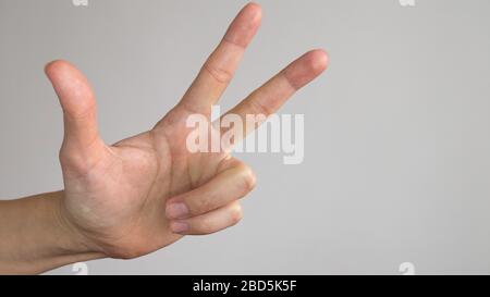 The left female hand shows three fingers on a white background. Symbol of Serbia. Stock Photo