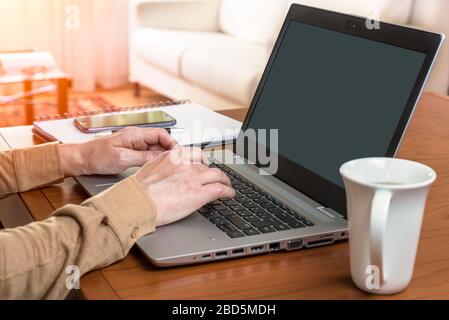Businesswoman working from home using laptop and smartphone during the coronavirus pandemic Stock Photo