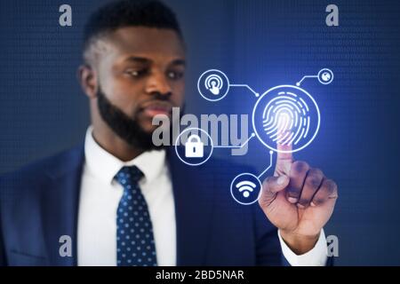 African Businessman Touching Virtual Panel For Fingerprint Scanning, Blue Background Stock Photo