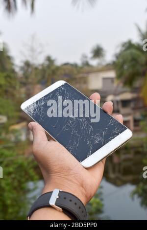 Broken device screen of a mobile phone. Cracked touch screen of digital tablet. Damaged old used technology Backgrounds. Stock Photo
