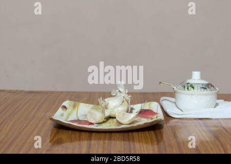 Garlic Salt on wooden table. Garlic salt is a seasoned salt made of a mixture of dried, ground garlic and table salt with an anti-caking agent ( calci Stock Photo