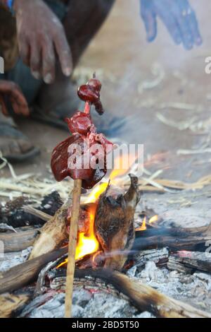 Hunted animal meat is drying in the sun at a Hadzabe village ...
