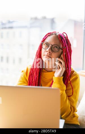 Digital nomad concept. Girl freelancer remotely working on laptop in cafe, coworking. Stock Photo