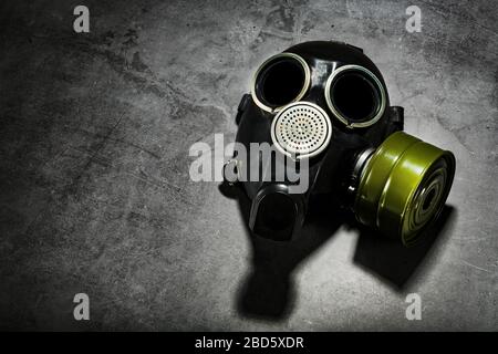 Gas mask on a black stone background, protection from dangerous infection. Stock Photo