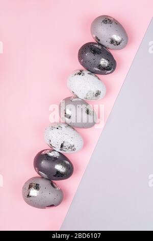 Easter eggs in two rows on grey and pink background. copy space. Stock Photo