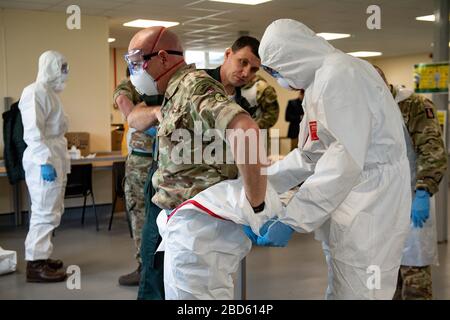 Members of the British Army learn how to apply PPE during training to support the Welsh Ambulance Service NHS Trust (WAST) in the battle against COVID-19 at the Sennybridge Training Camp in Mid Wales. Stock Photo