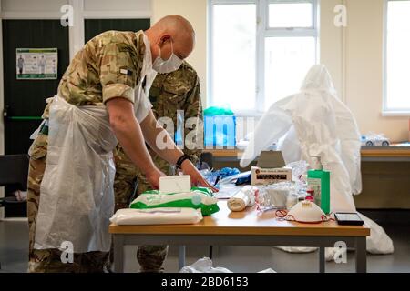 Members of the British Army learn how to apply PPE during training to support the Welsh Ambulance Service NHS Trust (WAST) in the battle against COVID-19 at the Sennybridge Training Camp in Mid Wales. Stock Photo