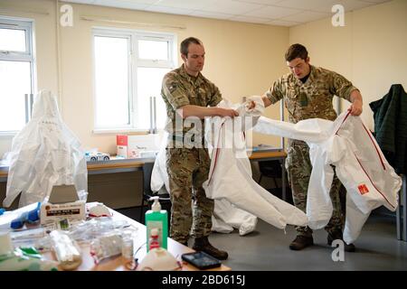 Members of the British Army learn how to apply PPE during training to support the Welsh Ambulance Service NHS Trust (WAST) in the battle against COVID-19 at the Sennybridge Training Camp in Mid Wales. Stock Photo