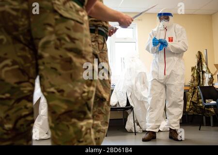 Members of the British Army learn how to apply PPE during training to support the Welsh Ambulance Service NHS Trust (WAST) in the battle against COVID-19 at the Sennybridge Training Camp in Mid Wales. Stock Photo