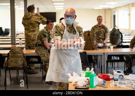 Members of the British Army learn how to apply PPE during training to support the Welsh Ambulance Service NHS Trust (WAST) in the battle against COVID-19 at the Sennybridge Training Camp in Mid Wales. Stock Photo