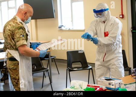 Members of the British Army learn how to apply PPE during training to support the Welsh Ambulance Service NHS Trust (WAST) in the battle against COVID-19 at the Sennybridge Training Camp in Mid Wales. Stock Photo